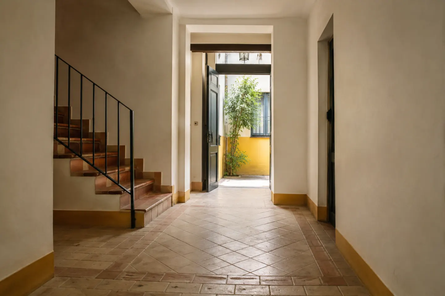 Acceso de edificio residencial con escalones y espacio de circulación