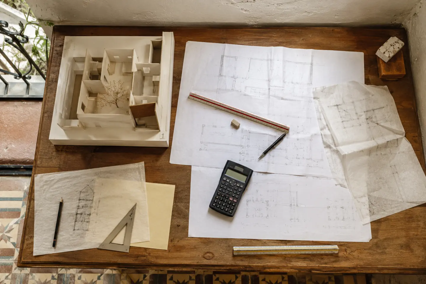 Maqueta doméstica junto a mediciones y calculadora sin importes comerciales ni logotipos
