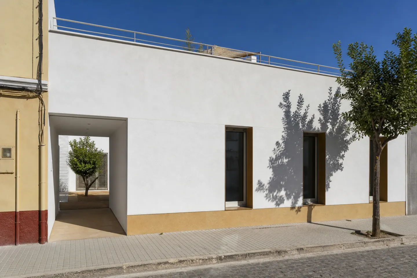 Vivienda unifamiliar de nueva planta con volumen blanco, huecos verticales y patio interior